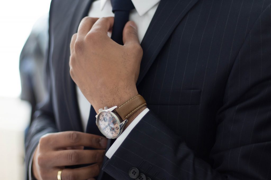 A man in a suit wearing a watch. 