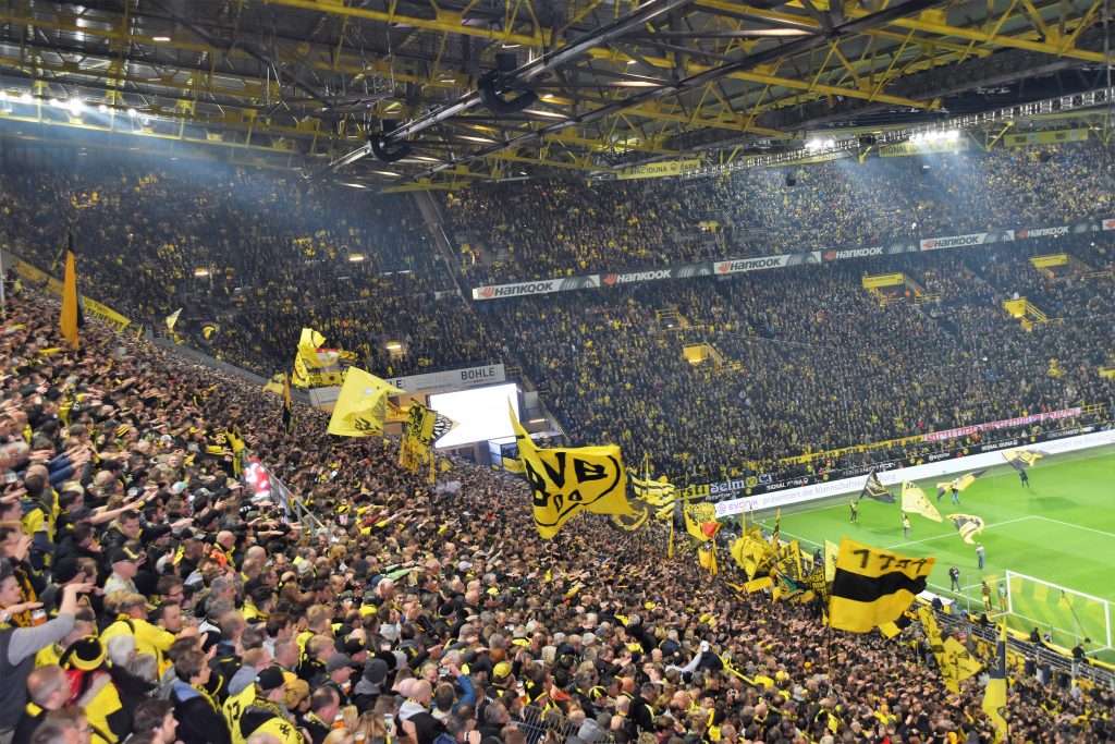 Enthusiastic Borussia Dortmund Fans Cheering During a Bundesliga Game